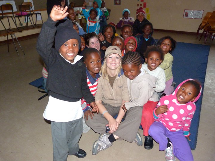 school children surrounding volunteer